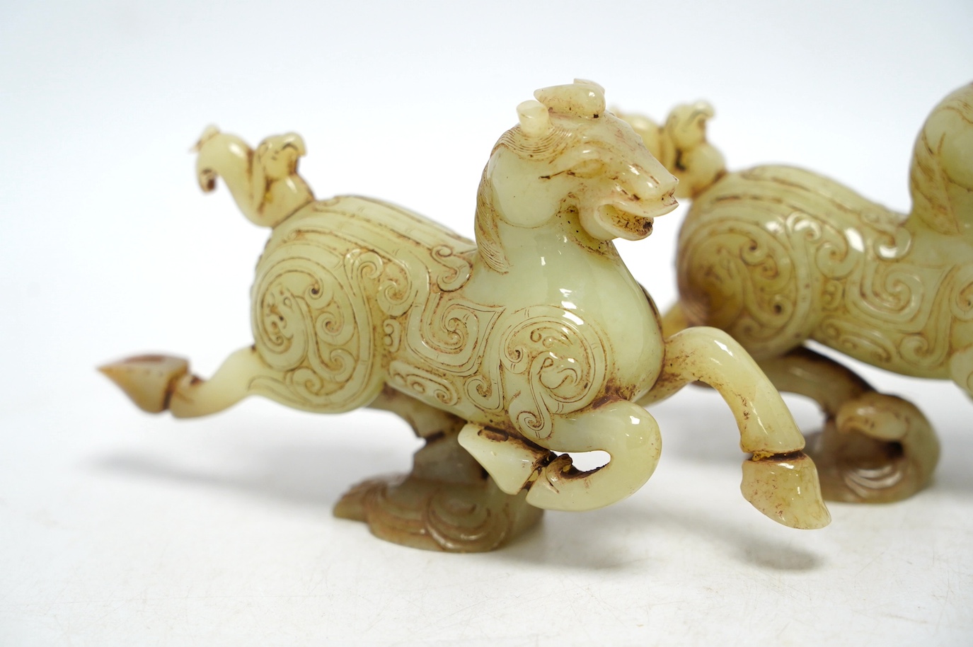 A pair of Chinese green jade horses, Han style, cased, 15cm wide. Condition - good